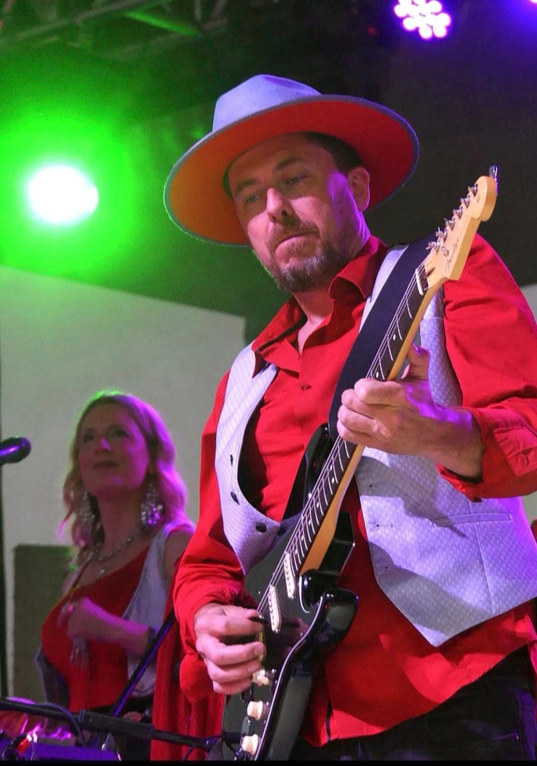 Alex playing electric guitar with Mia on vocals